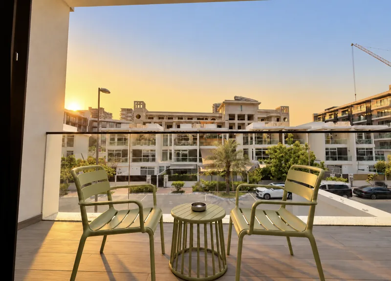 Pearl balcony with lime-green chairs, glass railing and views over neighbouring villas