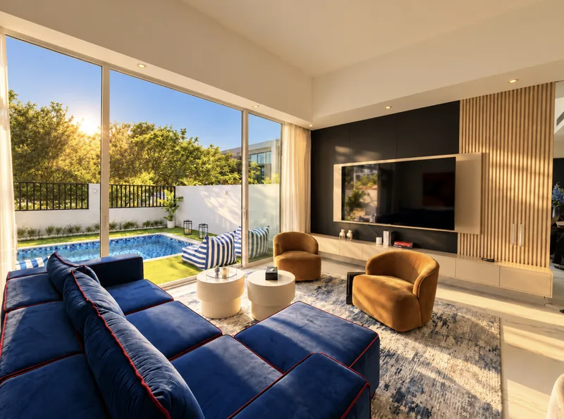Yasmin living room with blue sofa and glass doors opening to the pool