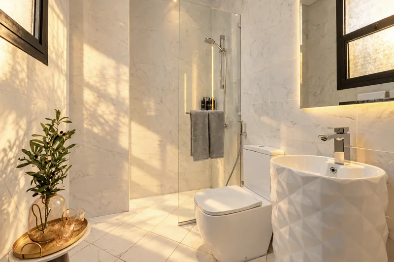 Zephyr bathroom with freestanding white basin, glass shower and marble walls