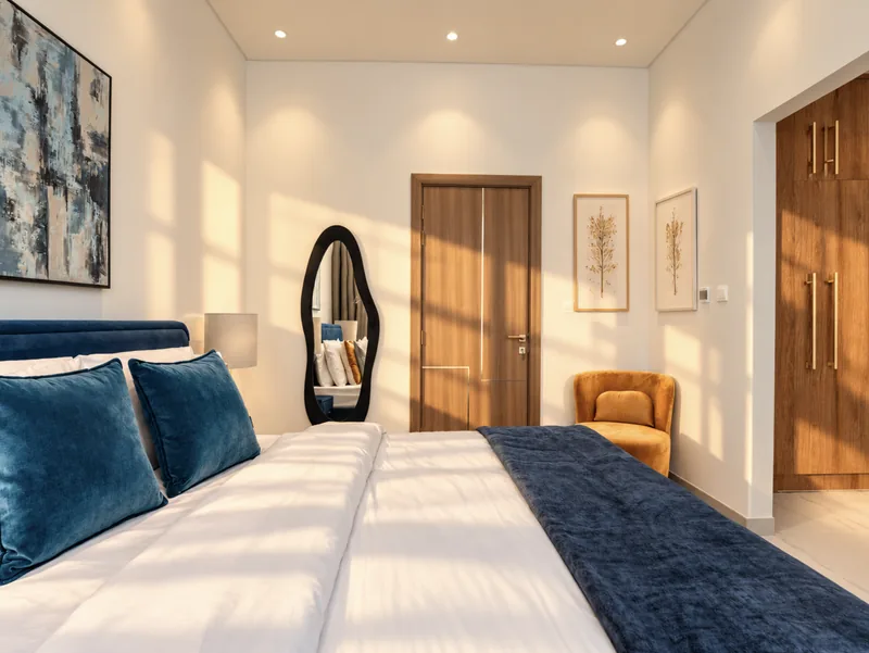 Zephyr navy bedroom with sculptural mirror, wall prints and en-suite door