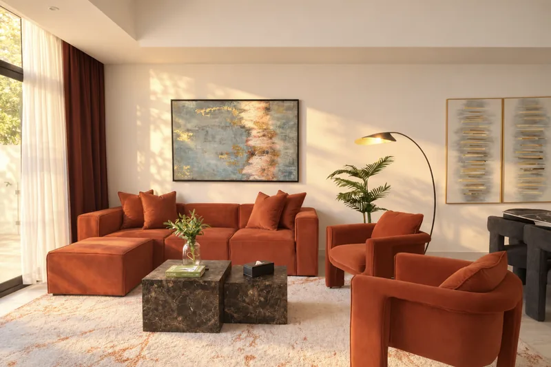 Zephyr lounge with rust sectional sofa, marble coffee tables and artwork