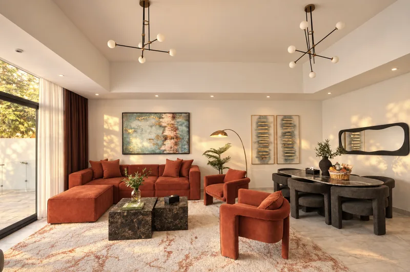 Zephyr open-plan living room with rust sofas, pendant lights and dining area